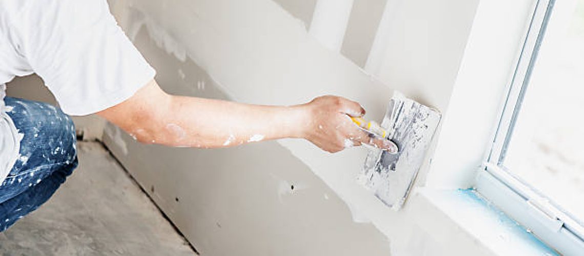 Man spackling new drywall or plasterboard
